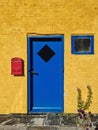 Yellow wall, blue doors, window, red post box - Bornholm Royalty Free Stock Photo