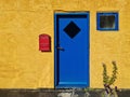 Yellow wall, blue doors, window, red post box - Bornholm Royalty Free Stock Photo