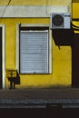 Yellow wall with closed shop blinds