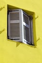 Yellow wall an old window shutters. Royalty Free Stock Photo