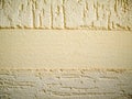 Yellow wall plastered with putty bark beetle different directions with non-plastered flat empty blank horizontal copyspace as Royalty Free Stock Photo