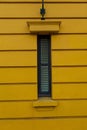 Yellow wall with a small tall green window