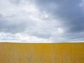 Yellow wall and stormy clouds sky in background Royalty Free Stock Photo