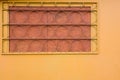 Yellow wall with trellised battened window.  Round elements of rack bar. Industrial construction closeup view with copy space Royalty Free Stock Photo