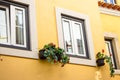 Yellow wall with windows and flower boxes. European architecture, Portugal. Facade decoration. Royalty Free Stock Photo