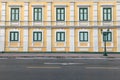 Yellow walls of building with windows beside road