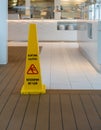 Yellow warning cone for wet floor in English and German Royalty Free Stock Photo