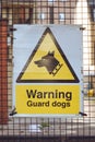 A yellow \'Warning Guard Dogs\' sign Royalty Free Stock Photo