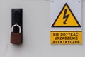Yellow warning sign and inscription on the electrical box in Polish language.