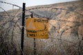 Yellow warning sign next to a mine field, close to the border with Syria, in the Golan Heights, Israel