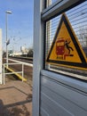 Yellow Warning Sign on a Railway Platform Illustrating the Danger of Falling Between the Train and the Platform. Royalty Free Stock Photo