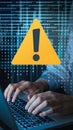 Yellow Warning Triangle Amid Binary Code, Typing Hands Suggest Cybersecurity Theme
