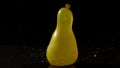 Yellow water balloon falling on black background