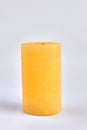 Yellow wax candle on white background. Decorative candle. Royalty Free Stock Photo
