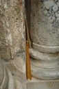 Yellow, wax, prayer candles lie in a cranny of stone pillars