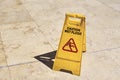 Yellow wet floor caution sign in summer day, closeup Royalty Free Stock Photo
