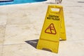 Yellow wet floor caution sign in summer day, closeup Royalty Free Stock Photo