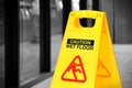 Yellow wet floor sign in a hallway, selective color Royalty Free Stock Photo