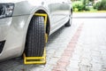 Yellow wheel clamp on an illegally parked car Royalty Free Stock Photo