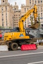 MOSCOW, RUSSIA - OCTOBER 24, 2017: Yellow wheel excavator Hyundai, working in urban environment next to the hotel `Ukraine`.