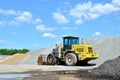 Yellow wheel loader on a cement production site.