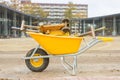 Yellow wheelbarrow with stone cutter on new pavement Royalty Free Stock Photo