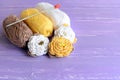 Yellow and white beaded crochet roses, skeins of cotton yarn, crochet hook on wooden background. Easy colored flowers patterns Royalty Free Stock Photo