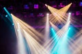 Yellow, white, and blue light rays from the spotlight through the smoke at the theater or concert hall Royalty Free Stock Photo