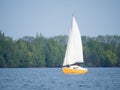 Yellow and white boat sailing on a lake on a sunny day Royalty Free Stock Photo