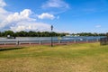 A yellow and white boat sailing through the vast green river water on the Savannah River with lush green trees and grass