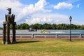 A yellow and white boat sailing through the vast green river water on the Savannah River with lush green trees and grass