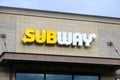 Yellow and white brand sign for Subway fast food restaurant