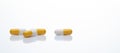 Yellow and white capsule pills on white background. Prescription drugs. Pharmaceutical industry. Health and medical care concept.