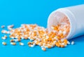 Yellow and white capsules pill spilled out from plastic bottle container. Healthcare, antibiotics drug resistance, pharmacy and Royalty Free Stock Photo
