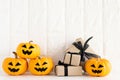 Yellow and white ghost pumpkin with gift box on white brick bloc