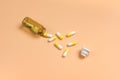 Yellow and white pills in the brown glass bottle on a orange background Royalty Free Stock Photo