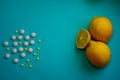 Yellow and white pills and lemons on a blue background