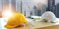 Yellow white safety helmet on workplace desk office center at construction site, contractor concept