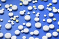 Yellow and white tablets scattered on a blue medical table, background Royalty Free Stock Photo