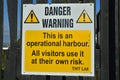 Yellow and white warning sign for operational harbour and risk Royalty Free Stock Photo