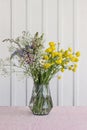 Wild flower bouquet in glass vase on table Royalty Free Stock Photo