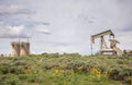 Yellow Wildflowers Around Oil Well and Tanks