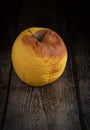 Yellow Wilted rotten apple on a wooden surface background