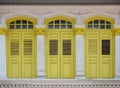 Yellow windows with shutters on white wall