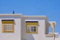 Yellow windows on a white wall arab house in Tunisia. White walls and roof