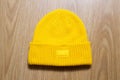 Yellow winter hat on wooden background, winter cap mock up Royalty Free Stock Photo