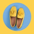 Yellow woman`s moccasins shoes in blue circle on yellow