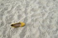 A yellow women`s shoe with heel on the sand on beach