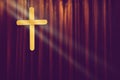 Yellow wood cross on dark brown curtain background in small church Royalty Free Stock Photo