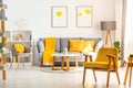 Yellow wooden armchair in bright living room interior with grey Royalty Free Stock Photo